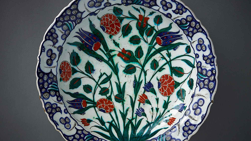 : A ceramic dish with a blue, red, and white floral pattern from 16th-century Turkey painting.