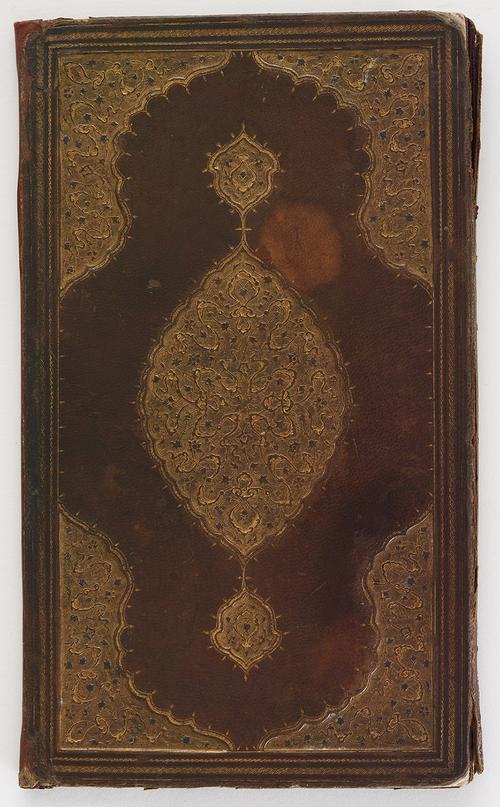 Brown leather book binding cover, decorated with central medallions and cornerpieces of gold-stamped floral motifs and cloudbands, the flower heads picked out in blue.