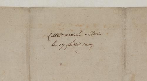 Detail of an inscription on the reverse of a letter, written in brown ink on beige paper. Inscription reads “Lettre arriveé a Paris le 17 février 1809.”