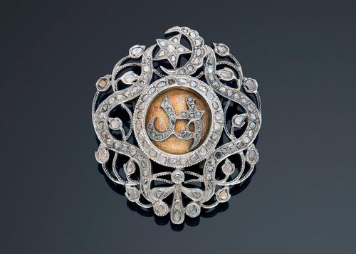 Plaque, with the monogram of Ahmed Pasha Bey, in gold and silver, chiselled and openwork decorated with floral garlands surmounted by a crescent and a star. It is entirely set with diamond roses with a golden center.