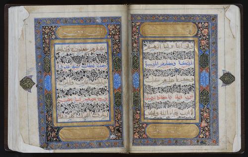 Open manuscript to a double page with five lines of text, between the text, black and white floral patterns. The text box is enclosed in a gold frame, with a blue border, and floral illumination. One medallion on each side, on the outer margins.