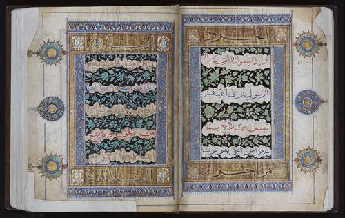 Open manuscript to a double page with five lines of text, between the text, green and black floral patterns. Above and below the text are boxes containing a calligraphic phrase and medallions. The text box is enclosed in a gold frame, with a blue border. Three medallions on the outer margins.
