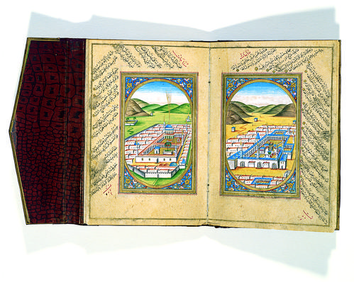 Double-page depicting Mecca on the right and Medina on the left side, each inserted in a gold ovoid border with floral motifs decorating the four corners of the composition. Both holy sites are rendered as a bird’s-eye view with similar organization.