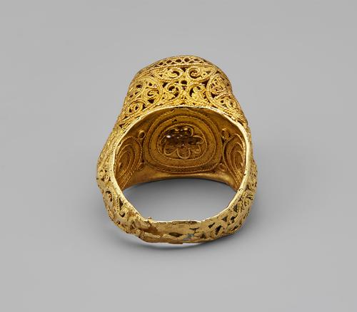 Bottom view of a stirrup-shaped ring gold ring with delicate filigree