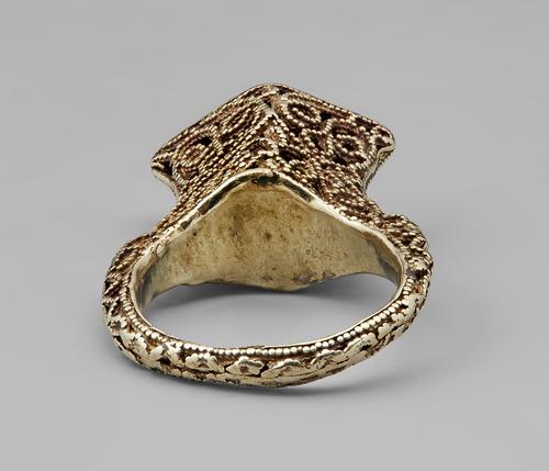 Bottom view of the golden ring featuring filigree and granulation, view of the inside of the band into the bottom of the rhombus shape.