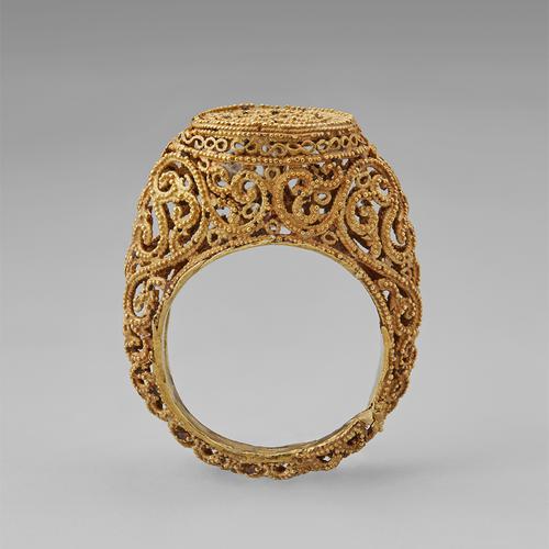 Opposite side view of the golden ring standing straight up on its band. Side view of the filigree and granulation that create this ring.  