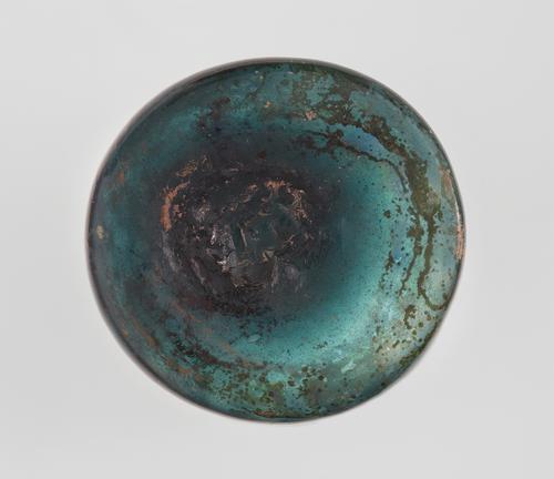 Bottom a blue/green glass beaker of cylindrical form.