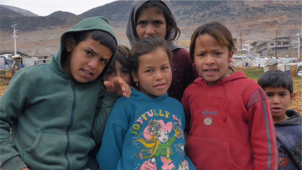 Syrian refugee children living in Lebanon pose for the camera in a still from the 2019 film Bitter Bread. 