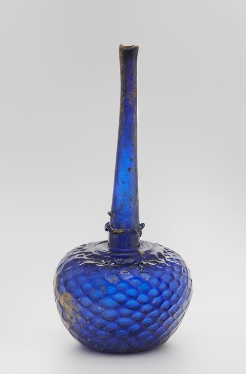 Blue glass bottle with globular body and tapering narrow neck with a trailed collar at the base, the body impressed with a honeycomb design.