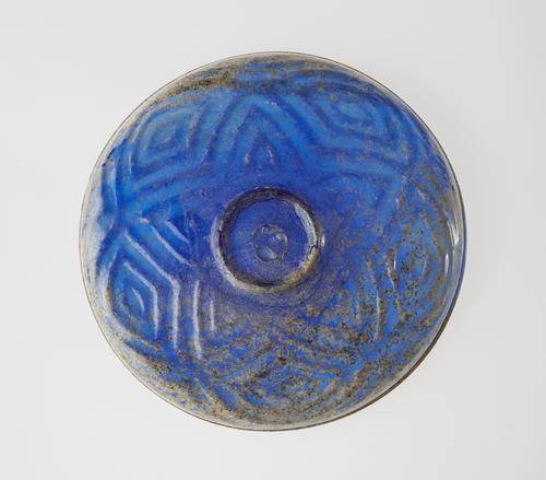 Bottom of a blue shallow dish, view of the five-pointed star decoration with enclosed triangles around the base and onto the  lower part of the walls.