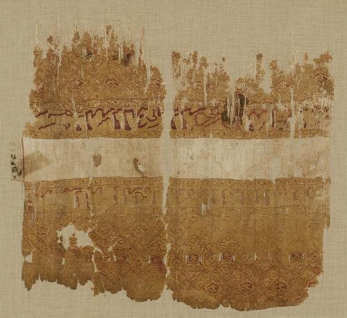 Fragment of a woven silk Tiraz with two bands of inscriptions in red running horizontally on top of a white band in the middle of the fabric. 