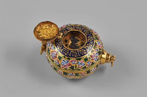 Gold compendium, circular palm sized form. The case elaborately decorated with polychrome-enamelled floral motifs. On the outside of the large compartment, and a band of royal blue with flowers on the edge beside of the small compartment, the lid of the small compartment flipped open.