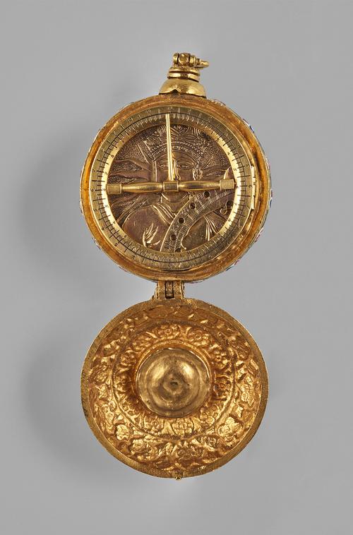 Open to the large compartment with a universal equinoctial dial comprising a hinged circle, folded ontop of a face decorated in relief with a depiction of a moustachioed man before radiating sunrays.