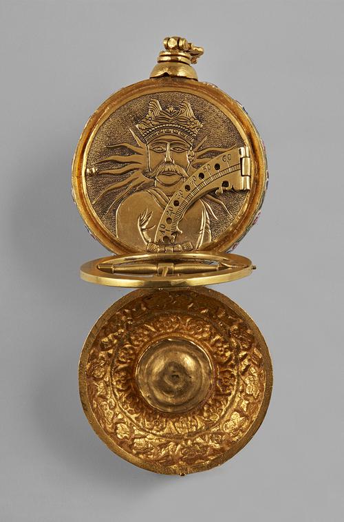 Open to the large compartment, the universal equinoctial dial flipped up, to view the hinged quarter-circle marked with latitudes, ontop of the face decorated in relief with a depiction of a moustachioed man before radiating sunrays. 