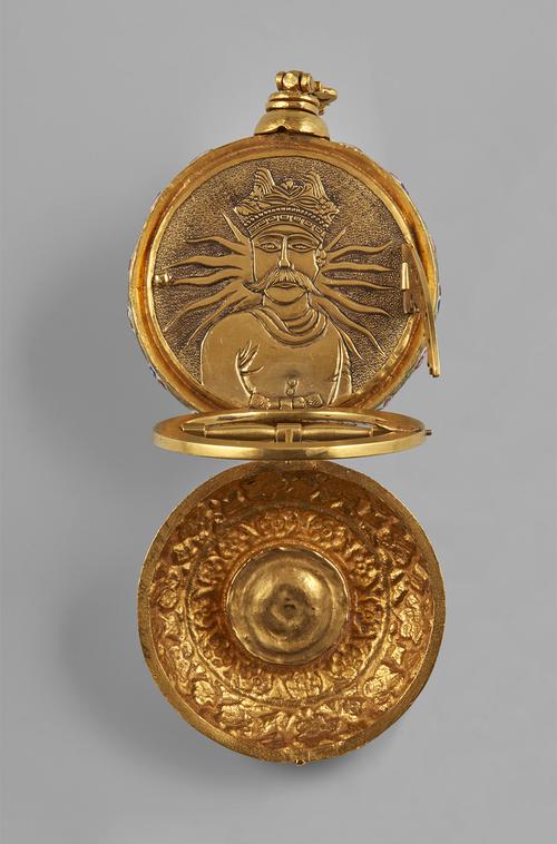 Open to the large compartment, the universal equinoctial dial comprising a hinged circle and hinged quarter circle flipped up to give a clear view of a face decorated in relief with a depiction of a moustachioed man before radiating sunrays.