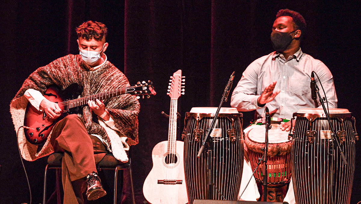 A guitarist and a conga drummer perform on stage at the Aga Khan Museum.