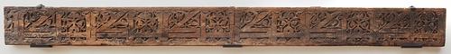 Wooden beam carved with kufic calligraphy and floral decoration.