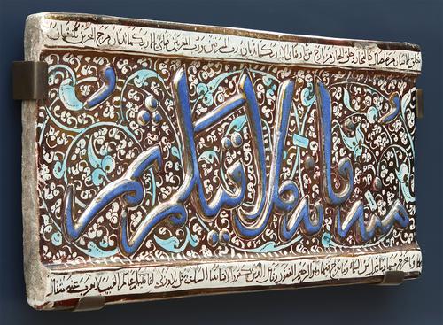 Side view of rectangular ceramic tile with Arabic and floral decoration, on mount.