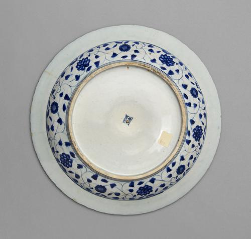 Bottom view of the dish, with blue and white designs cover the sides of the bowl, while the base and bottom of the rim are white.