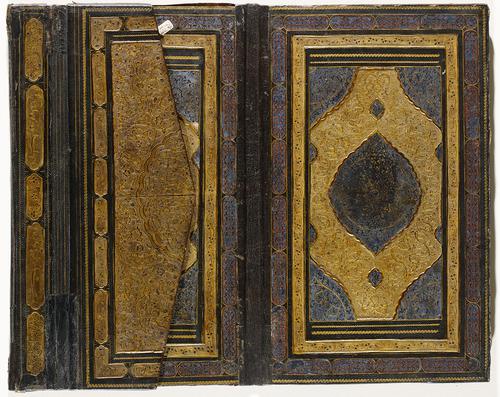 Interior of brown Morocco book binding, with flap flipped in towards the center, showing the exterior of flap with the gold gilt-stamping. 