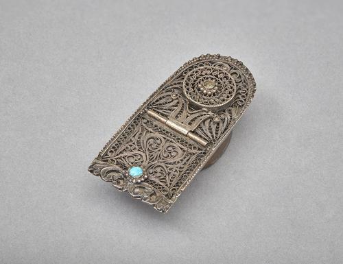 A silver inkwell with a turquoise stud and filigree design.  