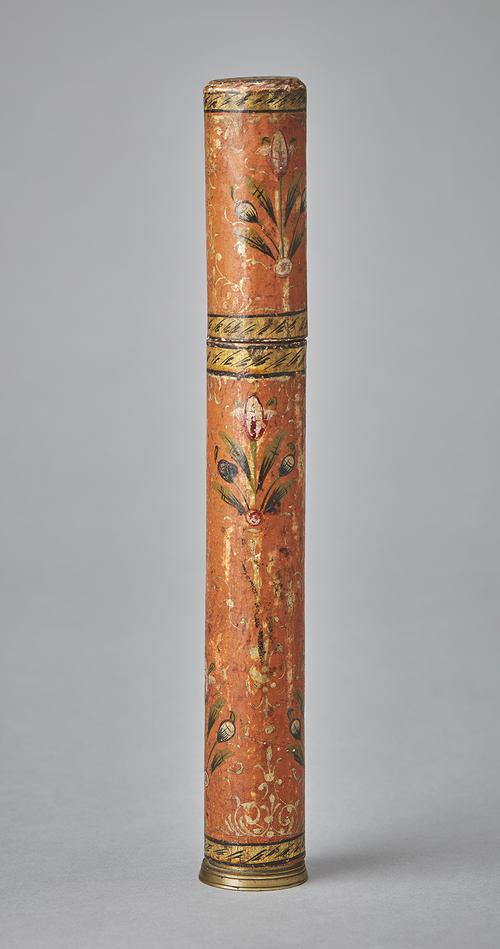 Cylindrical pen holder painted with floral designs and gold accents on orange background. 